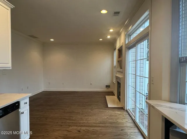 a view of a room with wooden floor and a window