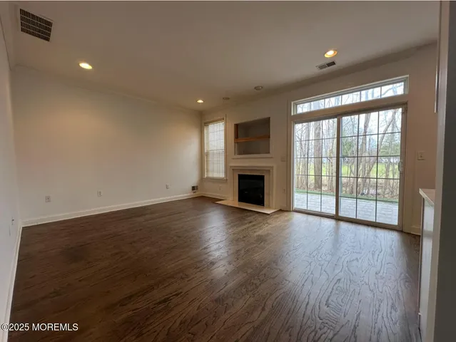 an empty room with wooden floor and fireplace
