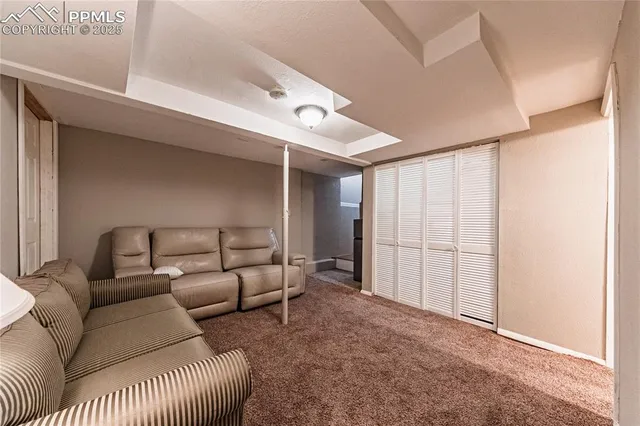 a living room with furniture and a ceiling fan