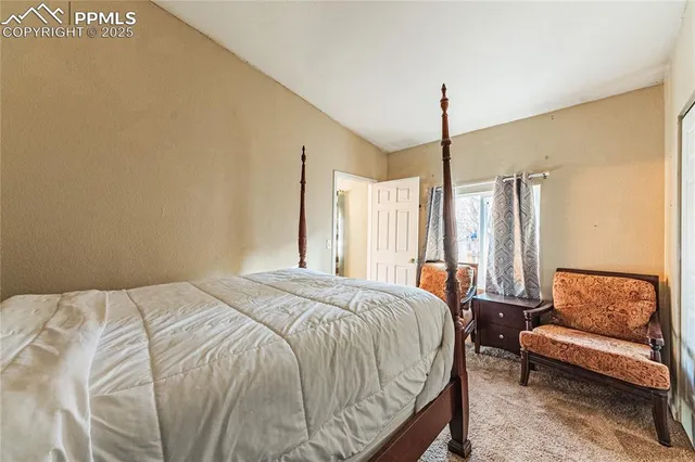 a bedroom with a bed couch and window