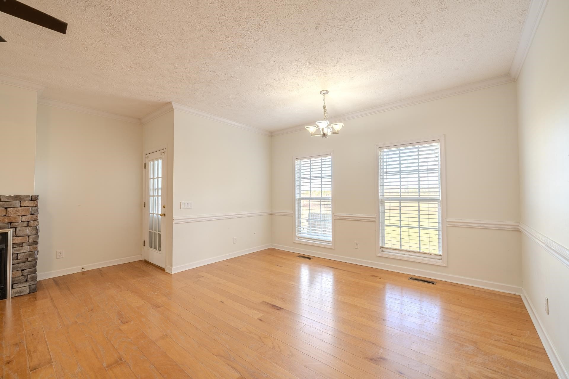 185 Leath Lane Finger, TN 38334 - Photo 12 of 34 an empty room with wooden floor chandelier and windows