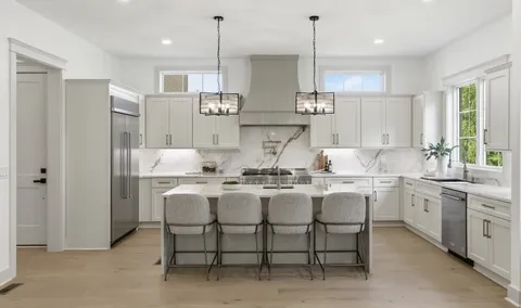 a kitchen with white cabinets and sink