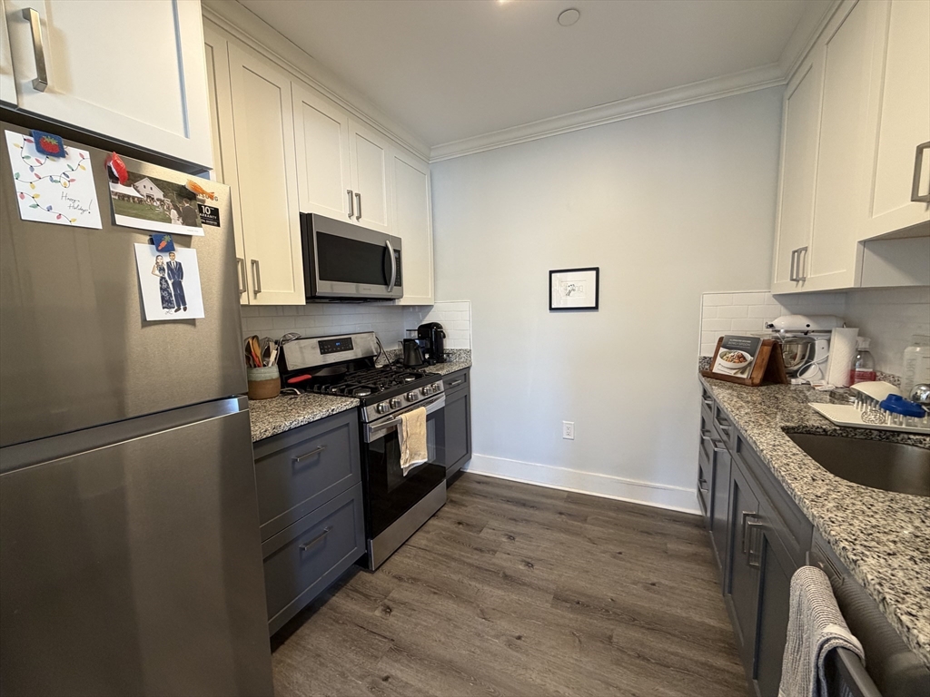 17 Hennery Way, Unit G Medfield, MA 02052 - Photo 7 of 12 a kitchen with granite countertop a stove and a refrigerator