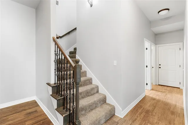 a view of a hallway with wooden floor and entryway