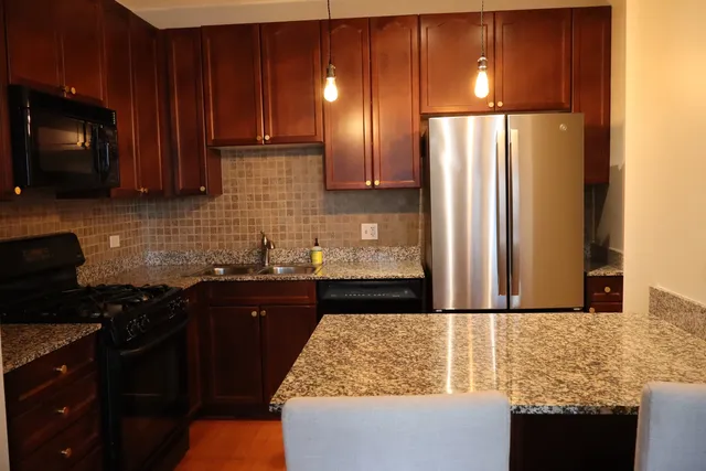 a kitchen with granite countertop wooden cabinets and a stove top oven