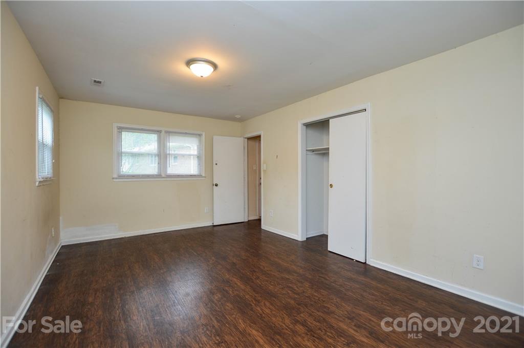 807 Squirrel Hill Road Charlotte, NC 28213 - Photo 18 of 34 an empty room with wooden floor and windows