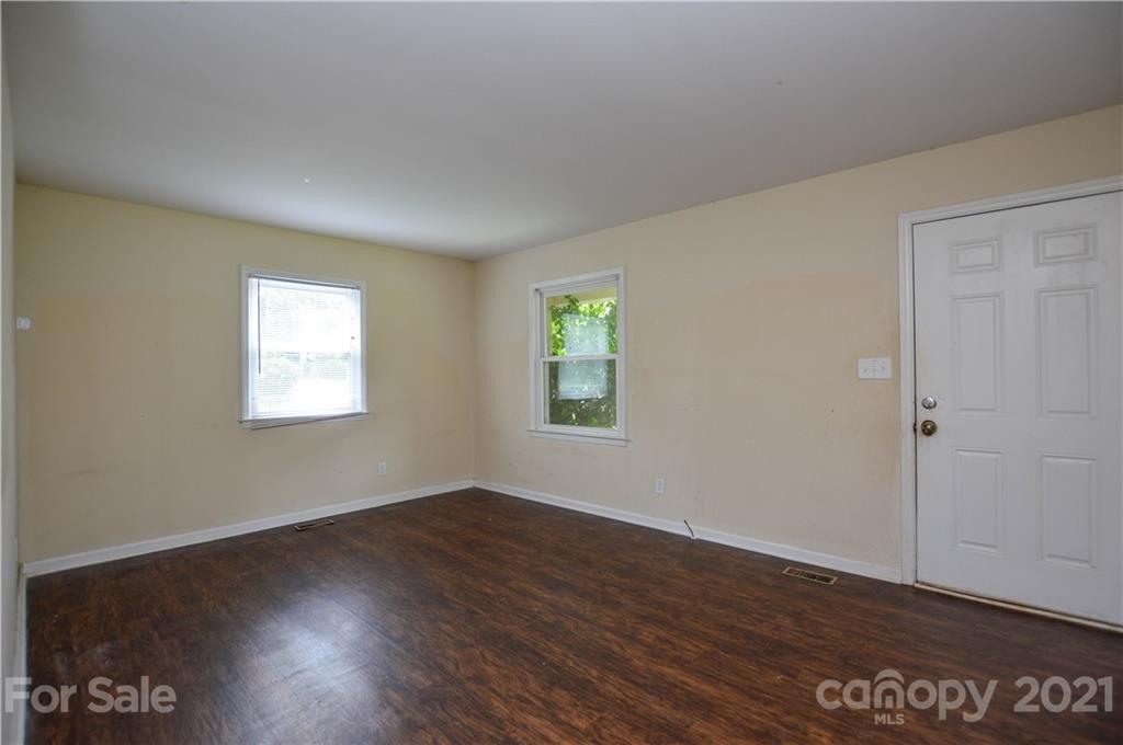 807 Squirrel Hill Road Charlotte, NC 28213 - Photo 5 of 34 an empty room with wooden floor and windows