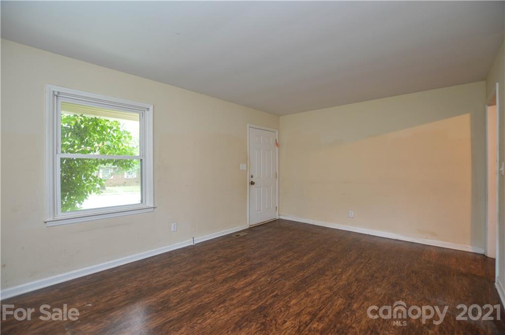 807 Squirrel Hill Road Charlotte, NC 28213 - Photo 6 of 34 an empty room with wooden floor and windows