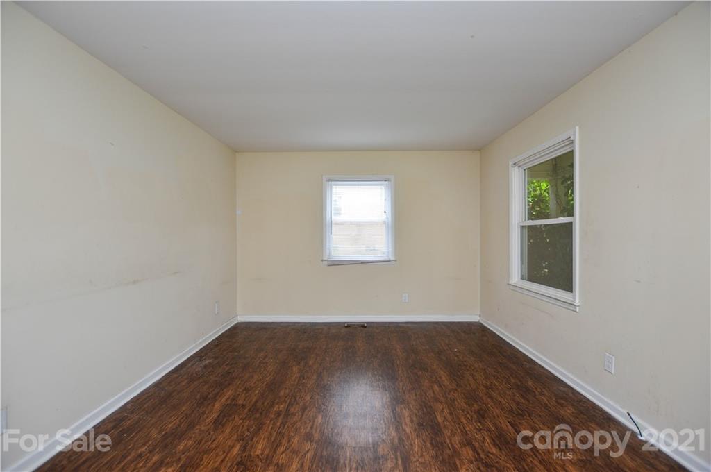 807 Squirrel Hill Road Charlotte, NC 28213 - Photo 8 of 34 an empty room with wooden floor and windows