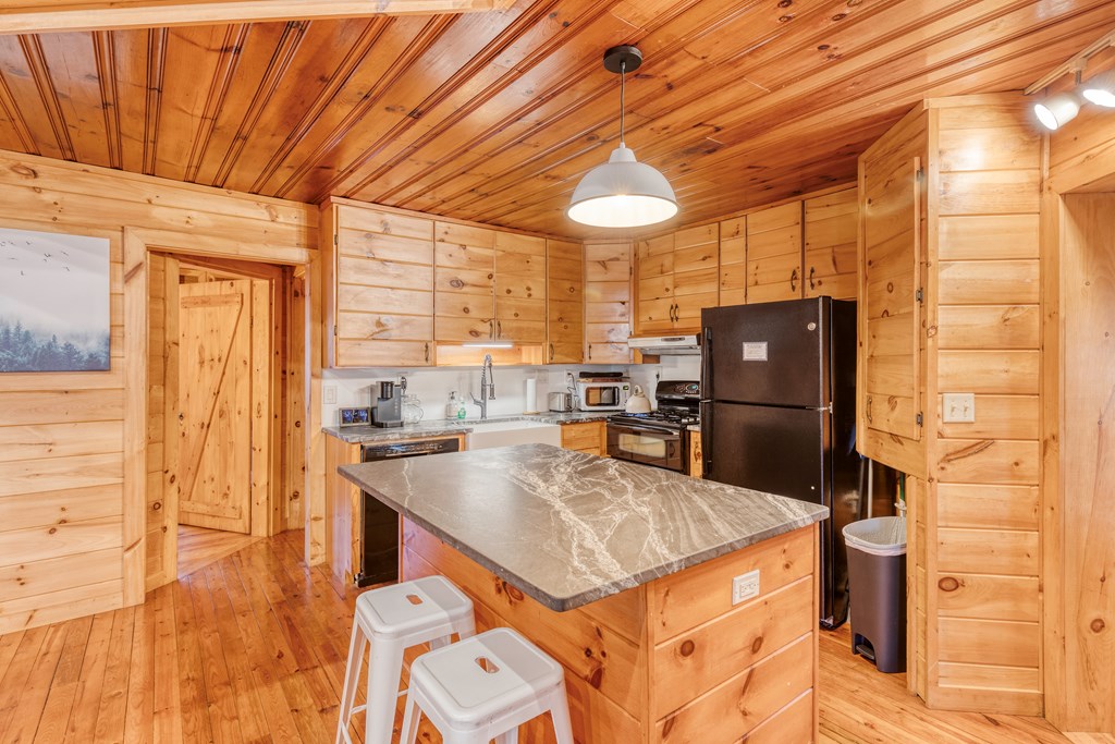 586 Newport Road Blue Ridge, GA 30513 - Photo 36 of 38 a kitchen with a sink a refrigerator and wooden cabinets
