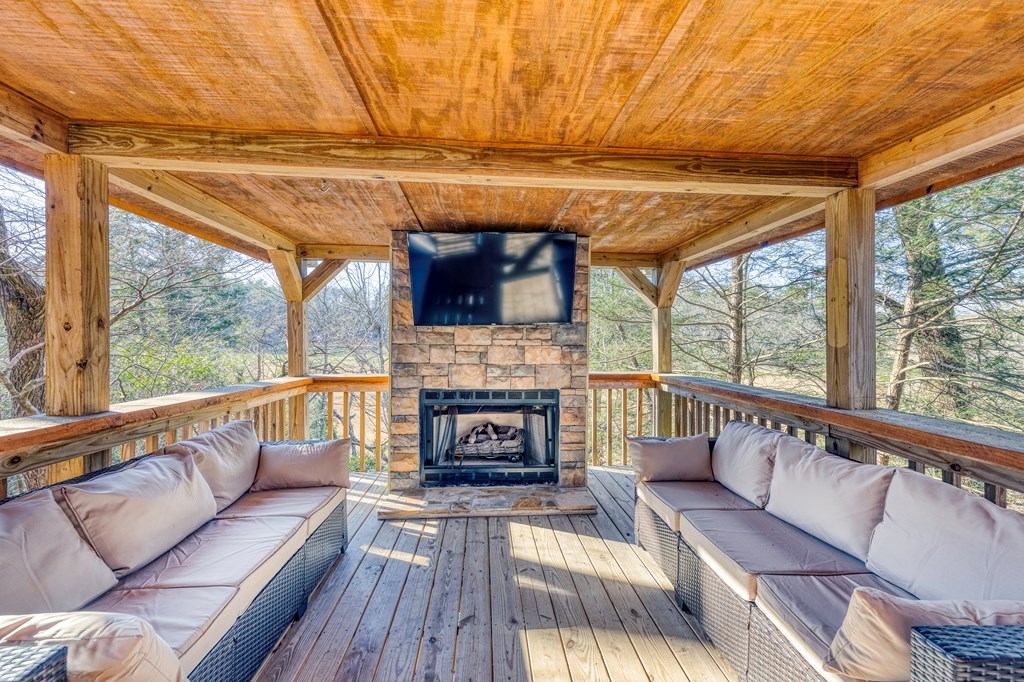 586 Newport Road Blue Ridge, GA 30513 - Photo 10 of 38 a living room with furniture a fireplace and a floor to ceiling window