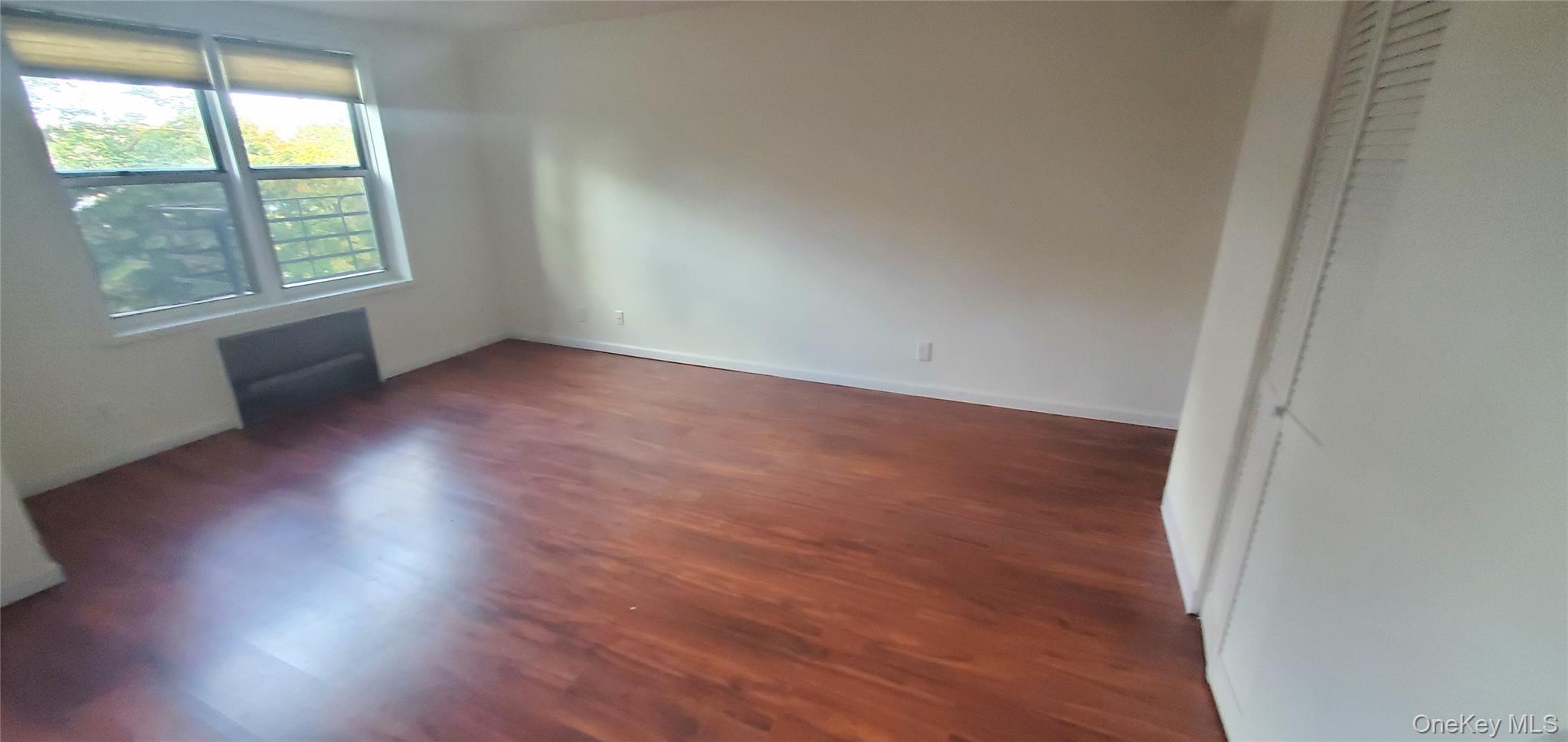 42 Pine Street, Unit 2E Yonkers, NY 10701 - Photo 19 of 24 an empty room with wooden floor and windows