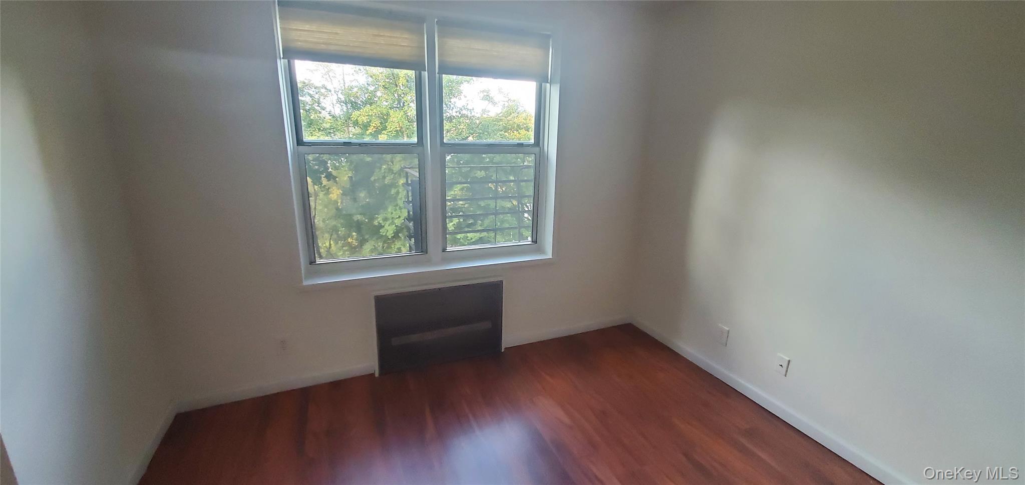 42 Pine Street, Unit 2E Yonkers, NY 10701 - Photo 20 of 24 an empty room with wooden floor and windows