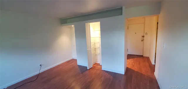 an empty room with wooden floor and a window