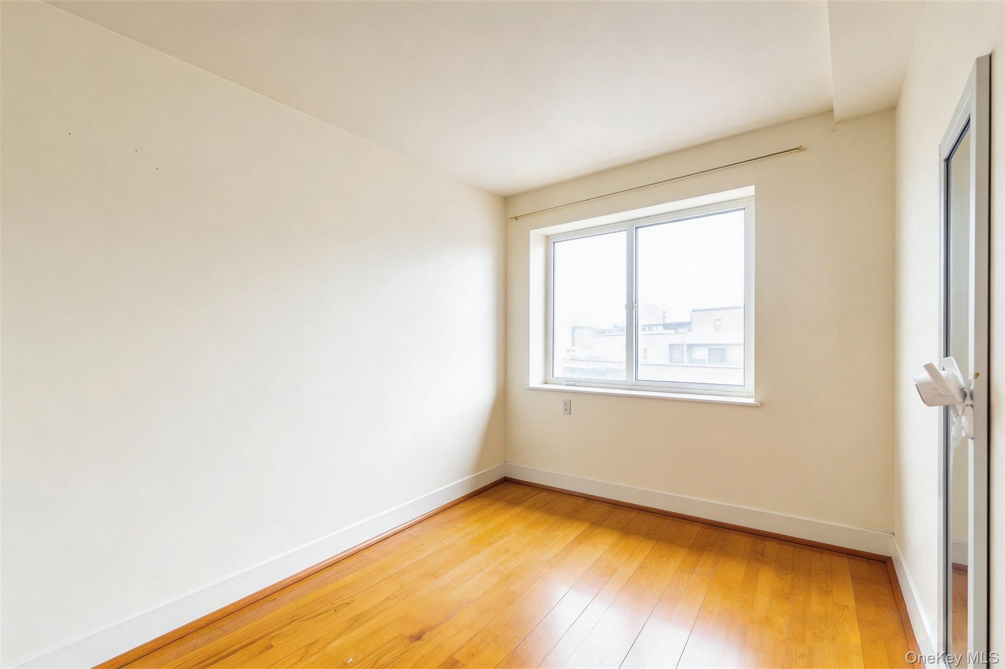 57-50 Granger Street, Unit 3A Queens, NY 11368 - Photo 11 of 20 Empty room featuring baseboards and light wood-style floors