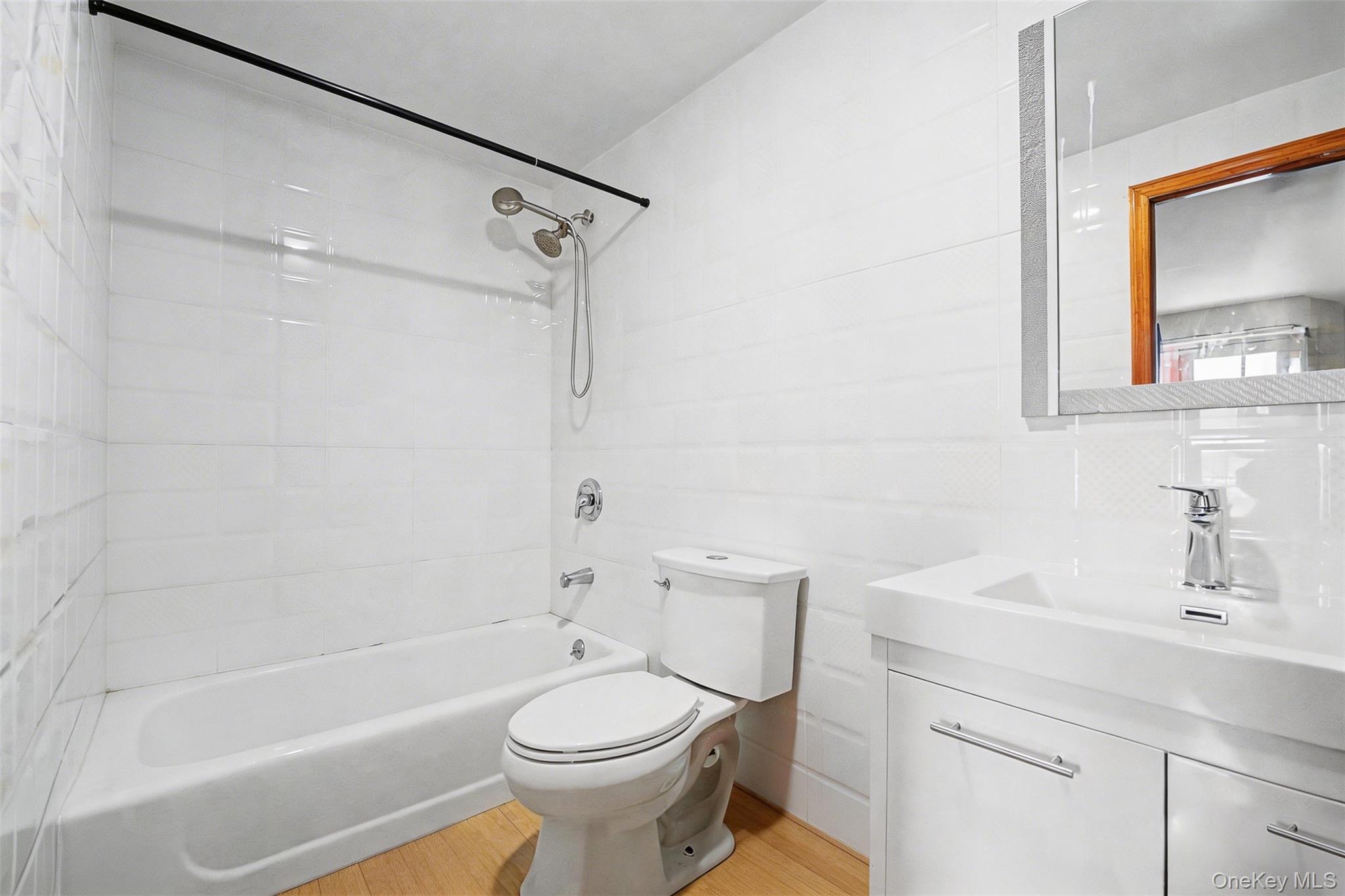 57-50 Granger Street, Unit 3A Queens, NY 11368 - Photo 14 of 20 Bathroom featuring vanity, shower / bathtub combination, light wood-style flooring, and tile walls