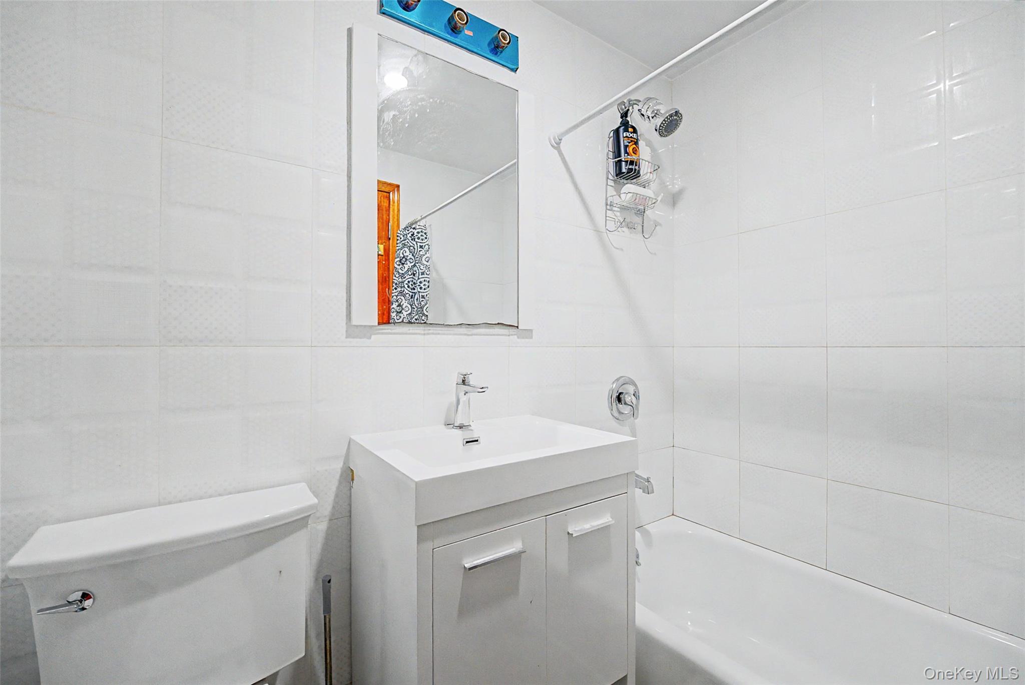 57-50 Granger Street, Unit 3A Queens, NY 11368 - Photo 15 of 20 a bathroom with a sink a toilet and mirror