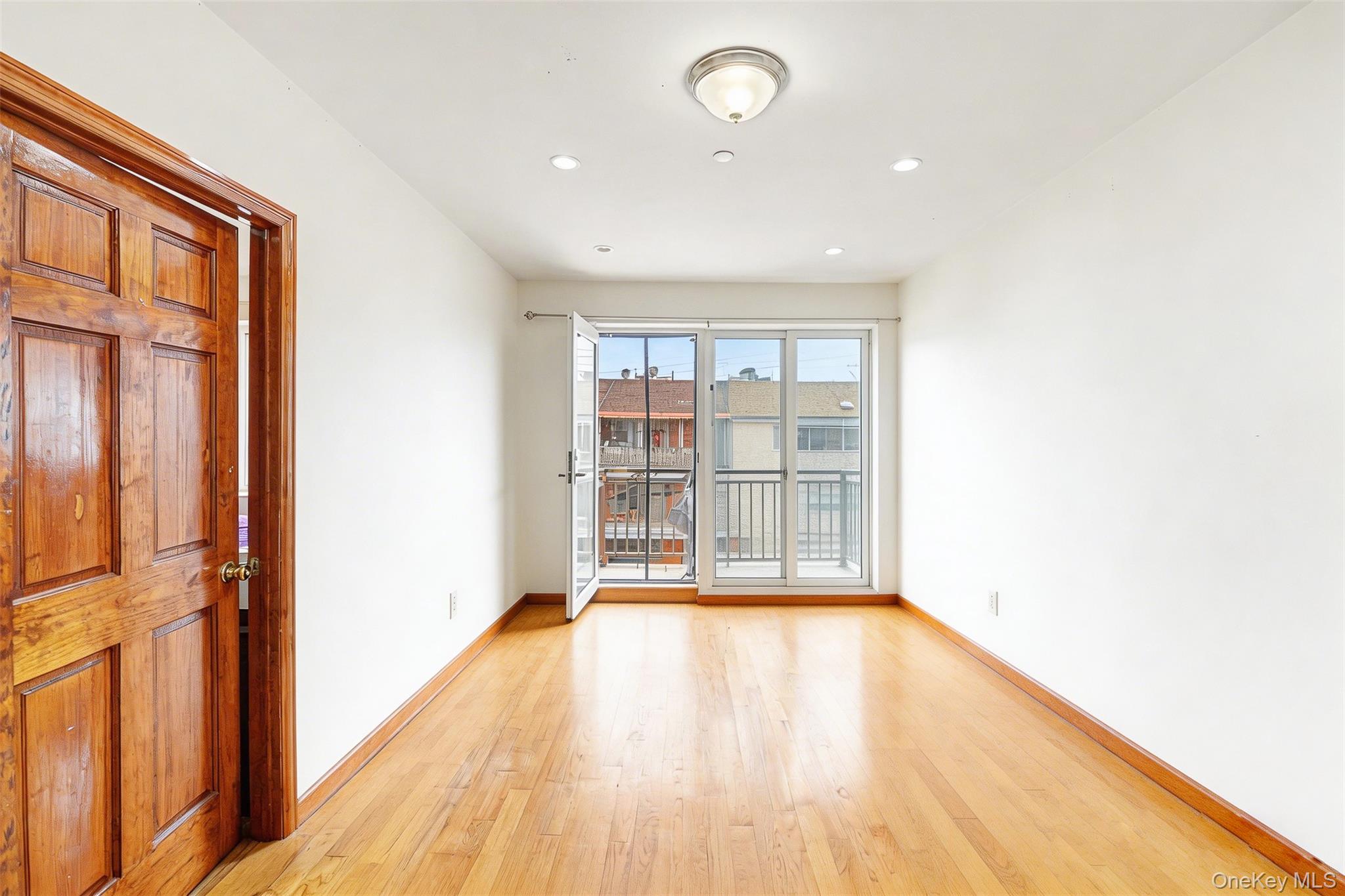 57-50 Granger Street, Unit 3A Queens, NY 11368 - Photo 2 of 20 a view of an empty room with wooden floor and a window