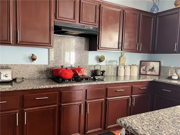 a kitchen with granite countertop wooden cabinets and sink