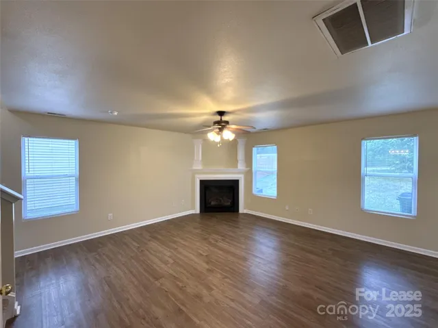 an empty room with windows and a fireplace