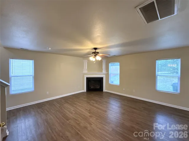 an empty room with windows and a fireplace