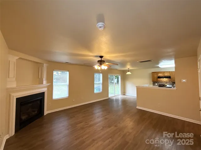 a view of an empty room with a fireplace and a window