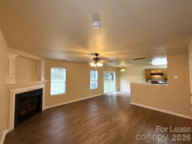 a view of an empty room with a fireplace and a window