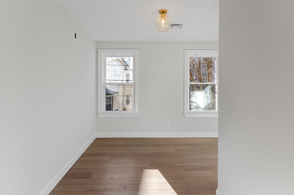19 George Street, Unit 3 Somerville, MA 02145 - Photo 15 of 20 a view of an empty room with wooden floor and a window