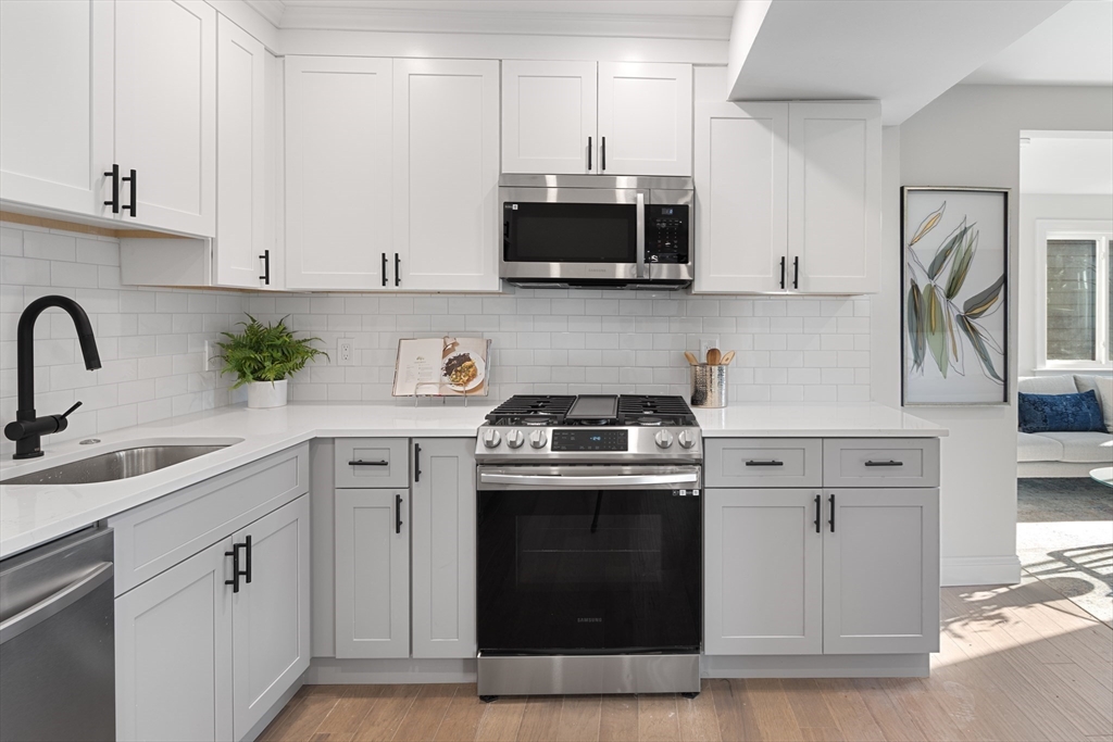 19 George Street, Unit 3 Somerville, MA 02145 - Photo 3 of 20 a kitchen with stainless steel appliances a stove a sink a microwave and cabinets