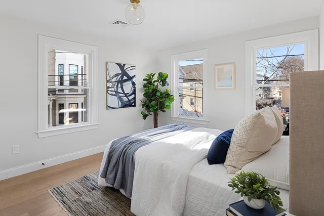 a bedroom with a bed and wooden floor