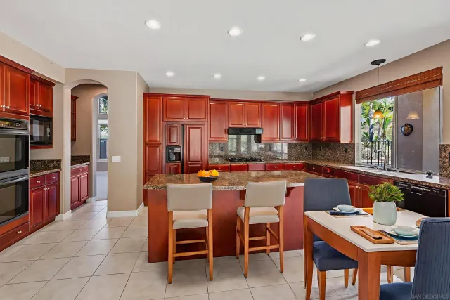 a large kitchen with stainless steel appliances granite countertop a stove and a refrigerator