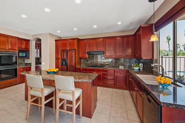 a kitchen with stainless steel appliances granite countertop a refrigerator and a sink