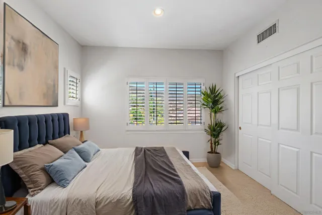 a bedroom with a bed and a painting on the wall