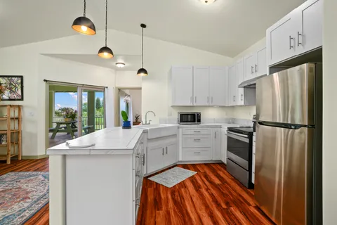 a kitchen with kitchen island white cabinets and stainless steel appliances