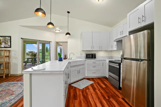 a kitchen with kitchen island white cabinets and stainless steel appliances