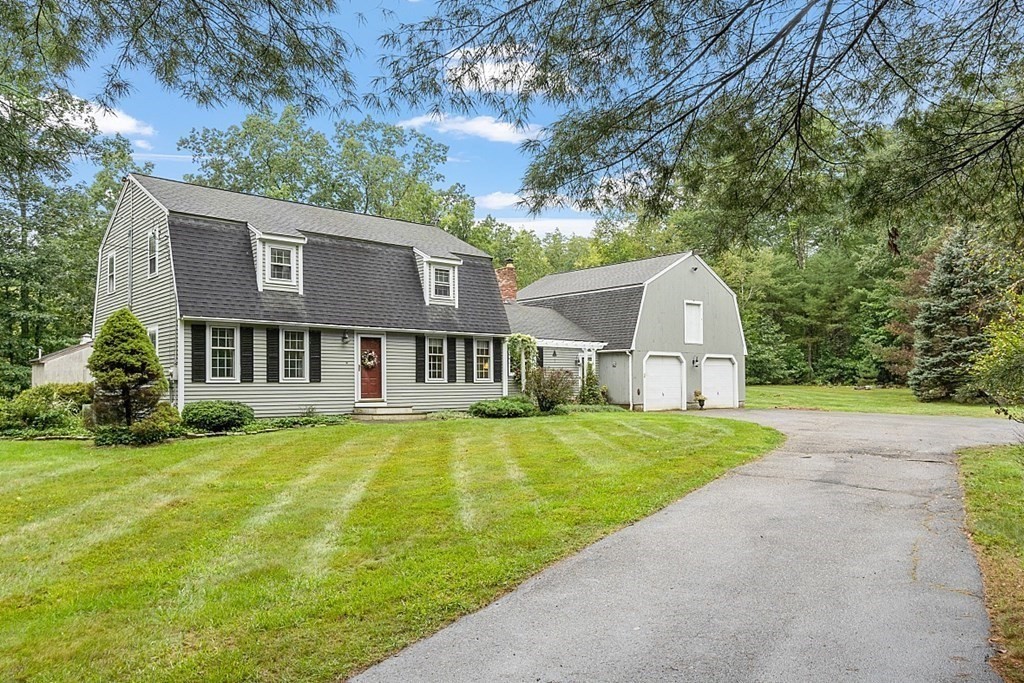 a front view of a house with yard and green space