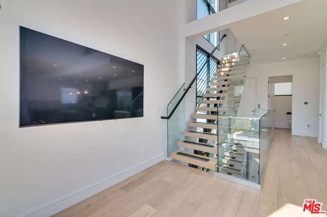 a view of a large room with wooden floor and windows