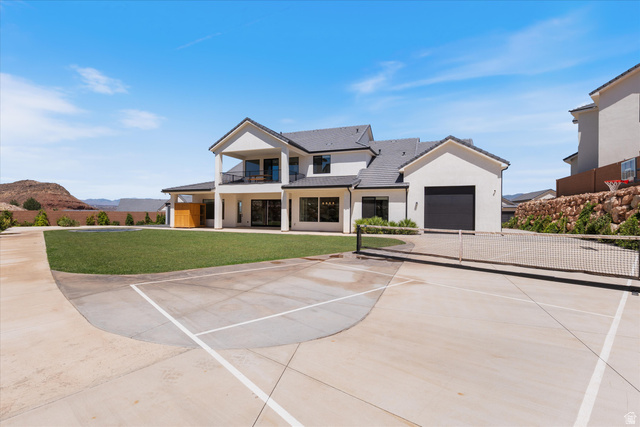 1192 East Corral Way Washington, UT 84780 - Photo 63 of 81 Expansive rear exterior featuring a multi-sport court with a tennis net, a large manicured lawn, and a covered patio area