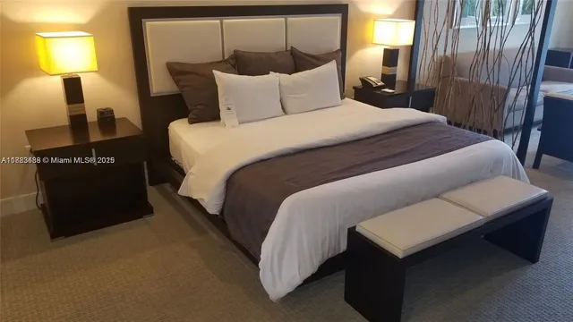 a large bed sitting in a bedroom next to a lamp