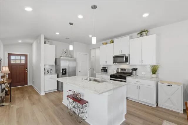 a kitchen with a sink stainless steel appliances and white cabinets