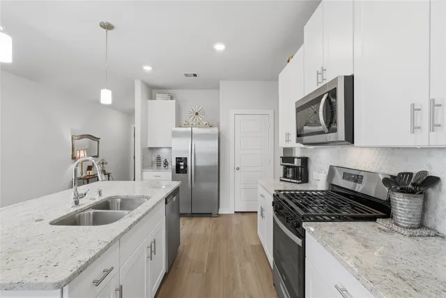 a kitchen with stainless steel appliances granite countertop a sink stove and refrigerator
