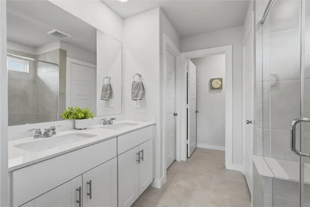 a bathroom with a double vanity sink mirror and shower