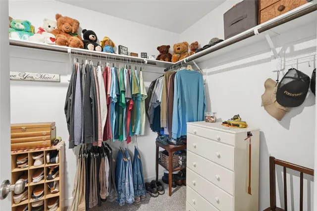 a view of walk in closet with clothes and shoes
