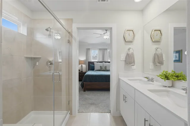 a en suite bathroom with a double vanity sink and a mirror