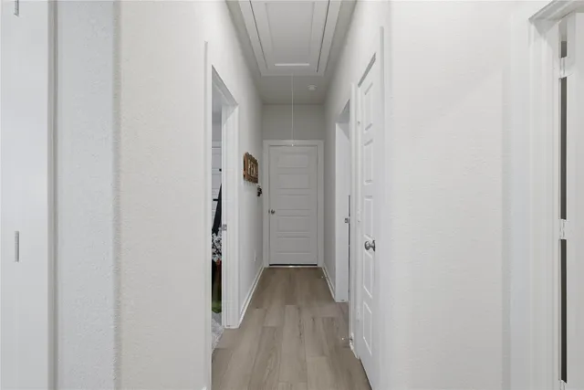 a view of a hallway with wooden floor and closet
