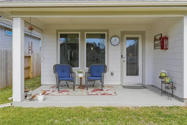 a front view of a house with a yard and large tree