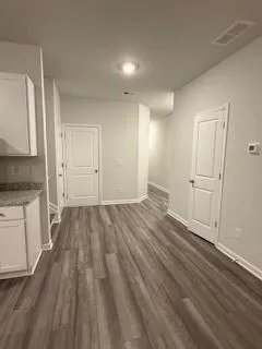 a view of a room with wooden floor and electronic appliances