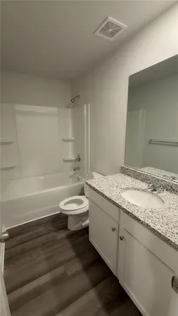 a bathroom with a granite countertop sink a toilet and bathtub