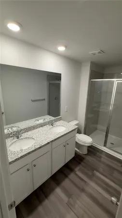a bathroom with a granite countertop sink and toilet