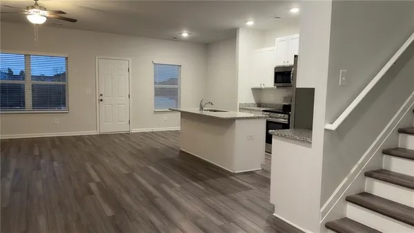 a view of a kitchen with wooden floor and electronic appliances